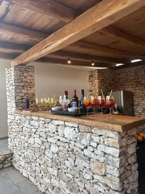 a stone bar with drinks on a stone wall at CasaCanetto villa, suites et piscine chauffée in Bonifacio