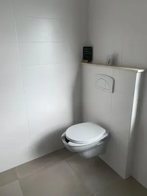 a bathroom with a white toilet in a stall at CasaCanetto villa, suites et piscine chauffée in Bonifacio