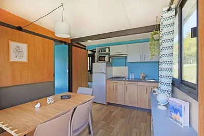 a kitchen with a table and a dining room at RAS L'BOL in Olmeto