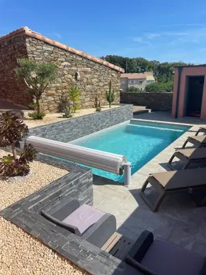 a swimming pool in a backyard with chairs and a pool at La Bergerie Furiani avec piscine privée Residence Digoune in Furiani
