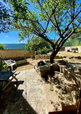 a picnic table and a tree in a yard at Casa Jeannot typique Corse en pierre, UNIQUEMENT DE SAMEDI EN SAMEDI , 2 pers, f2, 35 m2, jardin 60m2 vue montagne, parking in Monacia-dʼAullène