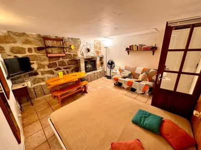 a living room with a couch and a table at Casa Jeannot typique Corse en pierre, UNIQUEMENT DE SAMEDI EN SAMEDI , 2 pers, f2, 35 m2, jardin 60m2 vue montagne, parking in Monacia-dʼAullène