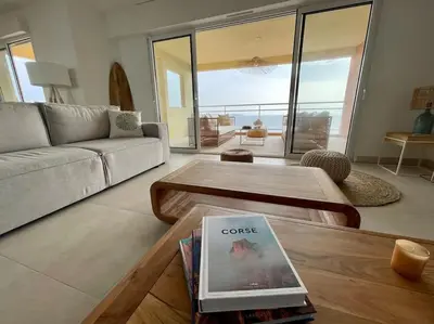 a living room with a couch and a coffee table at Paillote Perchée à 180 ° sur la mer in Ajaccio