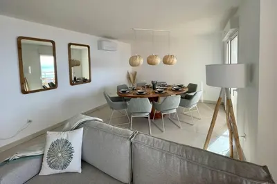 a living room with a couch and a table and mirrors at Paillote Perchée à 180 ° sur la mer in Ajaccio