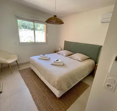 a bedroom with a bed with two towels on it at Paillote Perchée à 180 ° sur la mer in Ajaccio