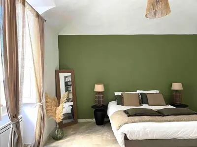 a bedroom with a large bed and a mirror at 83m2 de charme au coeur de la cité impériale in Ajaccio