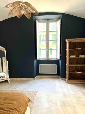 a blue room with a bed and a window at 83m2 de charme au coeur de la cité impériale in Ajaccio