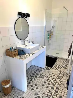 a bathroom with a sink and a mirror and a shower at 83m2 de charme au coeur de la cité impériale in Ajaccio