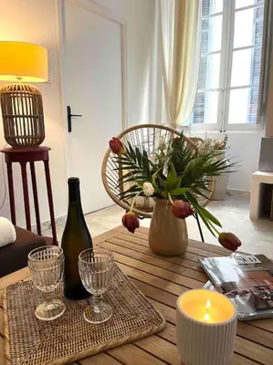 a living room with a table with a candle and a vase at 83m2 de charme au coeur de la cité impériale in Ajaccio