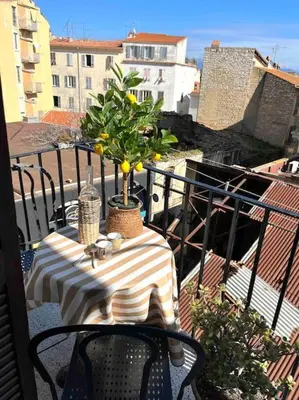 a table on a balcony with a lemon tree on it at 83m2 de charme au coeur de la cité impériale in Ajaccio