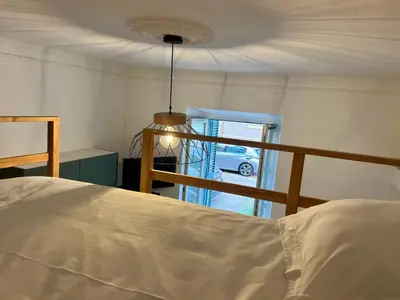a bedroom with a bed and a balcony with a car at Studio hyper centre in Ajaccio