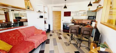 a living room with a couch and a kitchen at Magnifique appartement avec balcon vue mer à l'entrée d'Ajaccio in Ajaccio