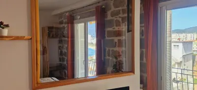 a mirror on a wall next to a window at Magnifique appartement avec balcon vue mer à l'entrée d'Ajaccio in Ajaccio