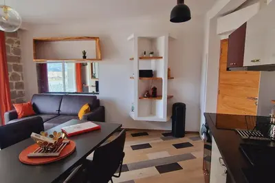 a living room with a couch and a table at Magnifique appartement avec balcon vue mer à l'entrée d'Ajaccio in Ajaccio