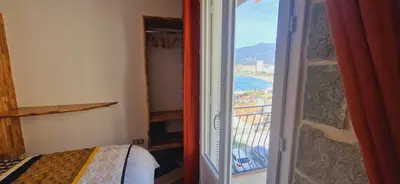 a bedroom with a door open to a room with a view at Magnifique appartement avec balcon vue mer à l'entrée d'Ajaccio in Ajaccio