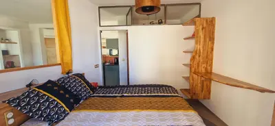 a small bedroom with a bed and a staircase at Magnifique appartement avec balcon vue mer à l'entrée d'Ajaccio in Ajaccio
