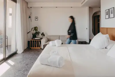 a white bedroom with a large bed with towels on it at Hotel Moderne in Porto-Vecchio