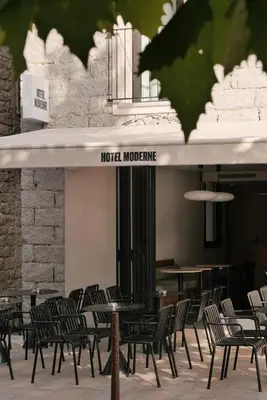 a row of tables and chairs in a restaurant at Hotel Moderne in Porto-Vecchio