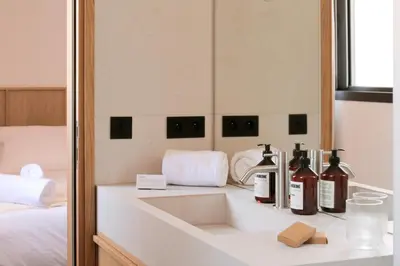 a bathroom with a sink with bottles of wine at Hotel Moderne in Porto-Vecchio
