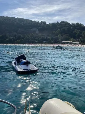 a small boat in the water near a beach at Villa avec piscine entièrement rénovée à 5min de la plage de pinia in Ghisonaccia
