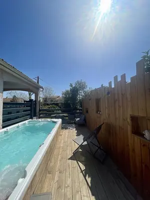 a swimming pool with a chair next to a wooden fence at Villa avec piscine entièrement rénovée à 5min de la plage de pinia in Ghisonaccia