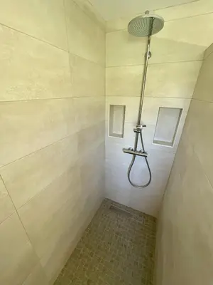 a bathroom with a shower with a light on the ceiling at Villa avec piscine entièrement rénovée à 5min de la plage de pinia in Ghisonaccia
