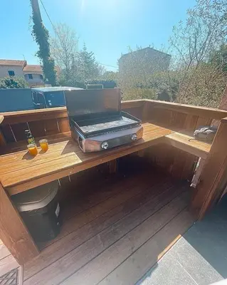 a laptop computer sitting on a wooden table on a deck at Villa avec piscine entièrement rénovée à 5min de la plage de pinia in Ghisonaccia