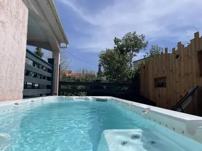 a hot tub in a backyard with a wooden fence at Villa avec piscine entièrement rénovée à 5min de la plage de pinia in Ghisonaccia