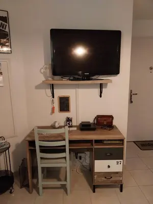 a desk with a television on top of a wall at Les villas de Mélody in Santa-Maria-Poggio