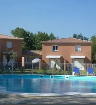a swimming pool in front of a house at Les villas de Mélody in Santa-Maria-Poggio