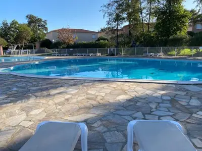 a large swimming pool with two chairs in front of it at Les villas de Mélody in Santa-Maria-Poggio