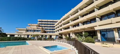 a large building with a swimming pool in front of it at STUDIO LES CALANQUES in Ajaccio