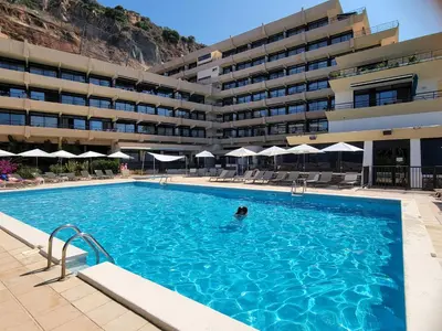 a person in a swimming pool in front of a building at STUDIO LES CALANQUES in Ajaccio