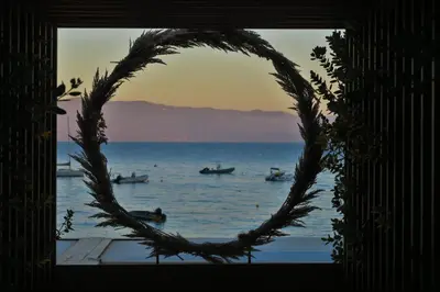 a round window with a view of the water with boats at STUDIO LES CALANQUES in Ajaccio