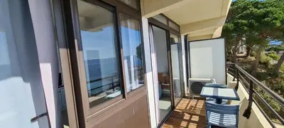 a balcony with glass doors and a view of the city at STUDIO LES CALANQUES in Ajaccio