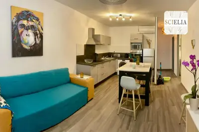 a living room with a blue couch and a kitchen at Chez Françoise in Porto Ota