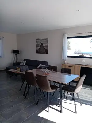 a living room with a table and chairs and a couch at côte et mer - appartement haut standing dans villa avec piscine et vue mer in Taglio-Isolaccio