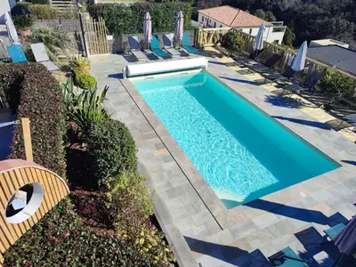 an overhead view of a swimming pool with chairs around it at côte et mer - appartement haut standing dans villa avec piscine et vue mer in Taglio-Isolaccio