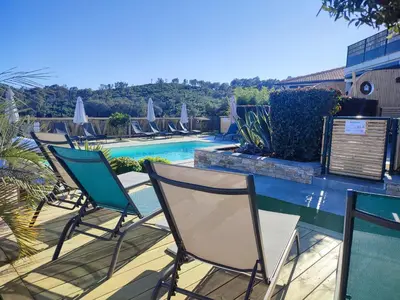 a group of chairs sitting around a pool at côte et mer - appartement haut standing dans villa avec piscine et vue mer in Taglio-Isolaccio