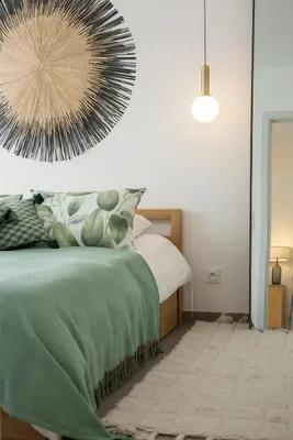 a bedroom with a green bed and a mirror at Domaine d'Arca - Hugo 06 - 2 pers in Porto-Vecchio