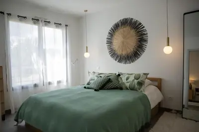 a bedroom with a bed and a mirror on the wall at Domaine d'Arca - Hugo 06 - 2 pers in Porto-Vecchio
