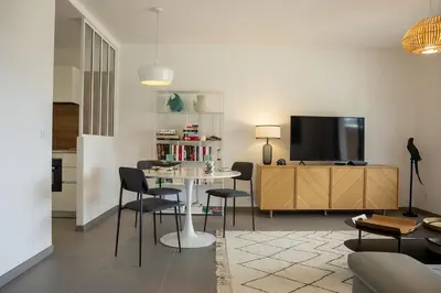 a living room with a table and chairs and a tv at Domaine d'Arca - Hugo 06 - 2 pers in Porto-Vecchio