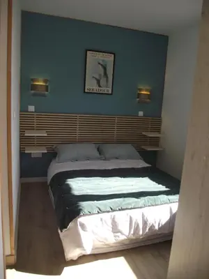 a bedroom with a large bed with a blue wall at mer et campagne in Cervione