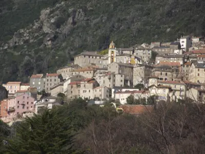 a town on a hill with a mountain at mer et campagne in Cervione