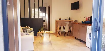 a room with a kitchen and a living room with a table at Casa in Castirla
