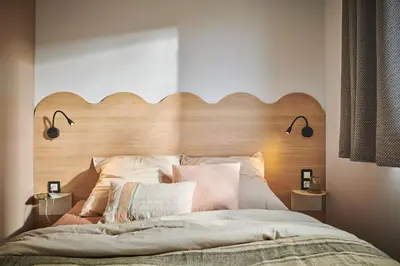 a bed with a wooden headboard in a bedroom at Camping California in Pinarellu