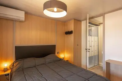 a bedroom with a bed and a lamp at Camping California in Pinarellu