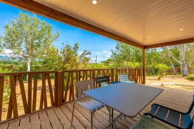 a patio with a table and chairs on a deck at Camping California in Pinarellu