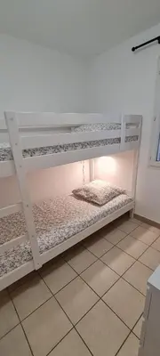 two bunk beds in a room with a light at Agréable rez de jardin avec Piscine et Jacuzzi in Cervione