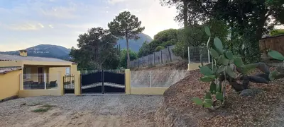 a house with a fence and a cactus at Agréable rez de jardin avec Piscine et Jacuzzi in Cervione